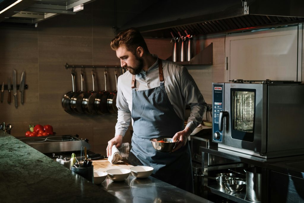 Organiser un évènement d'entreprise à Paris - un homme cuisine dans la cuisine d'un restaurant 